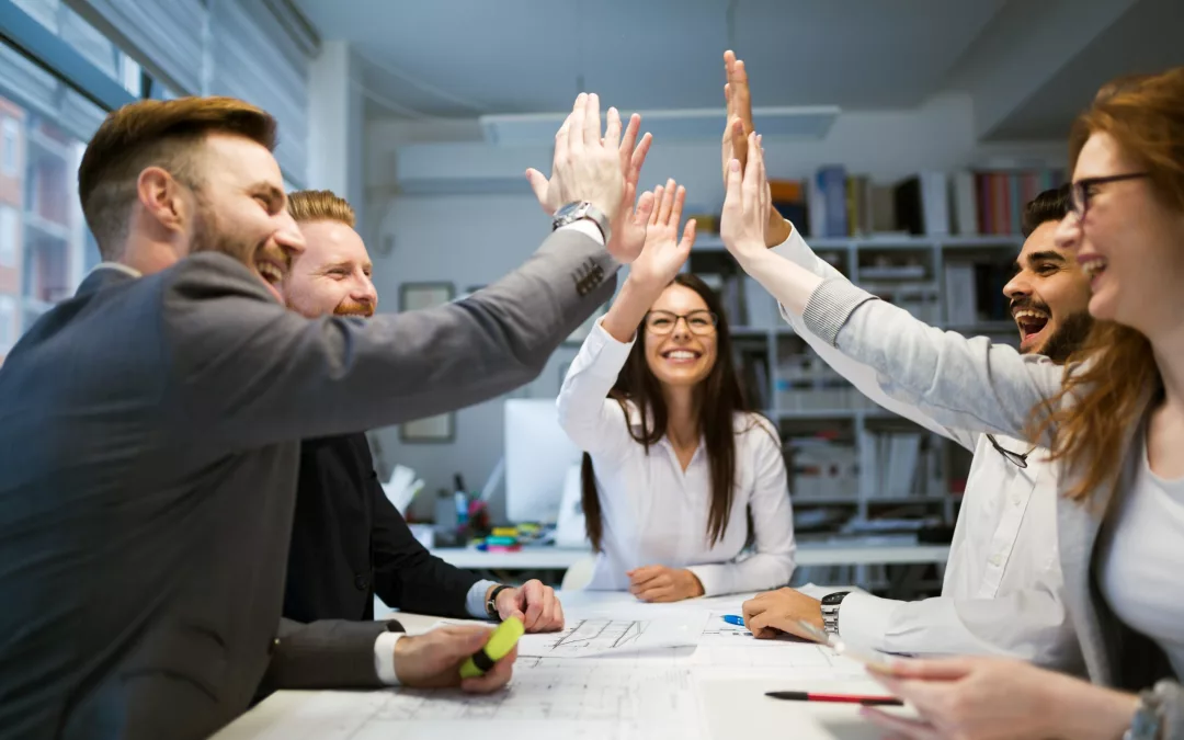 Mitarbeitende arbeiten zusammen und geben zusammen einen high five